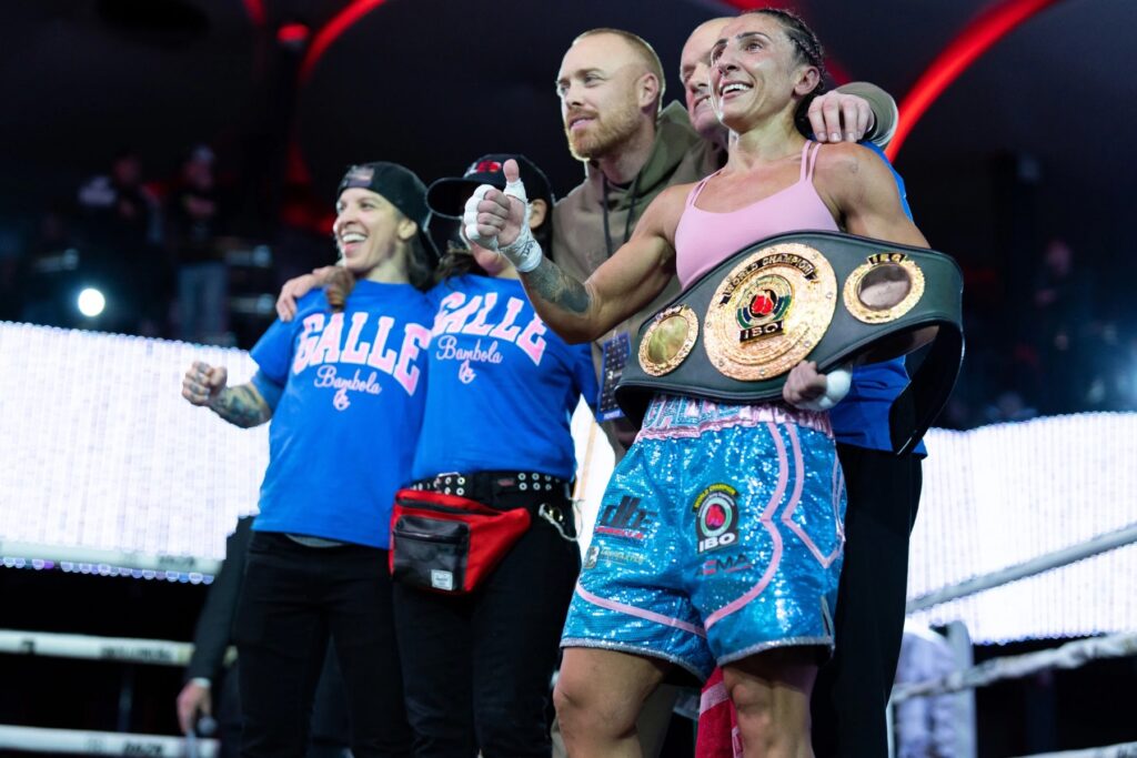 Amanda Galle celebrates victory with her team, honoring her family's strength and support.